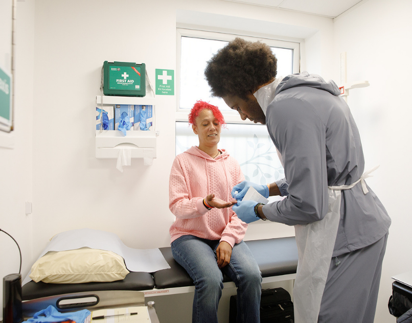 Health worker carrying out a BBV test by taking a small blood sample from a client's finger at CDAS