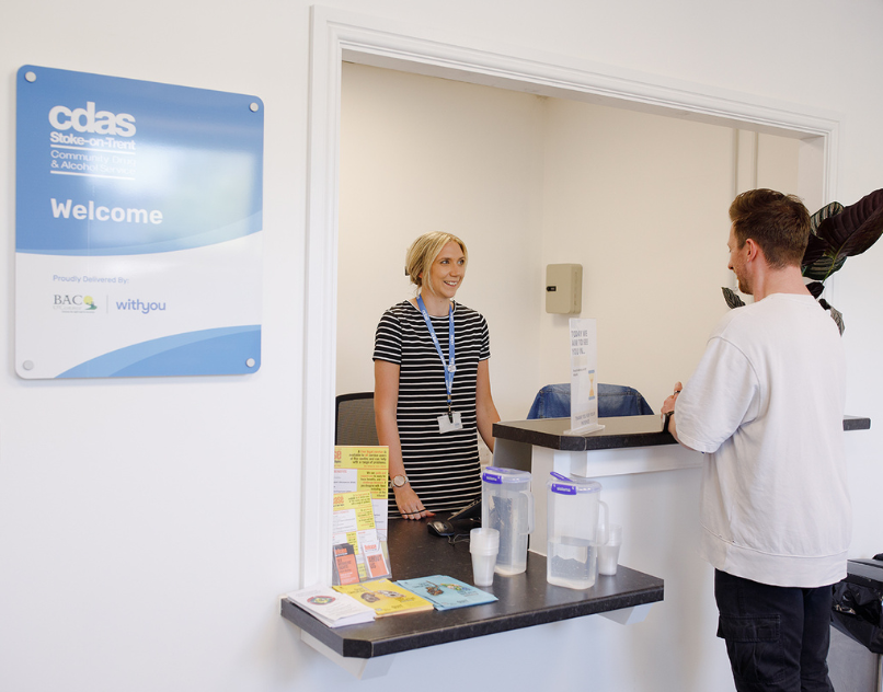 Staff member welcoming a visitor to the CDAS reception at Whittle Court in Hanley