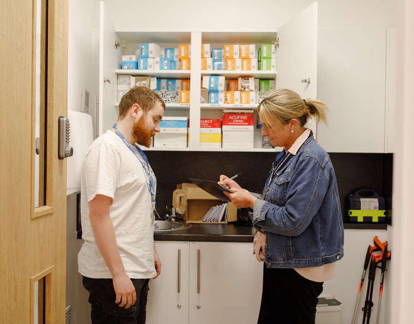Two CDAS staff members discussing harm reduction supplies in a clinical room