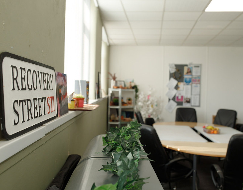 Interior of Stoke Recovery Service with tables, chairs, and a Recovery Street sign