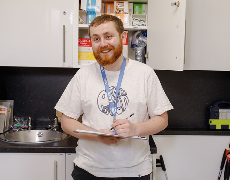 Smiling staff member holding a clipboard in one of the clinical rooms at CDAS Whittle Court