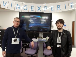 Two People Standing beside a television screen