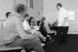 A photograph showing people in a seated waiting area