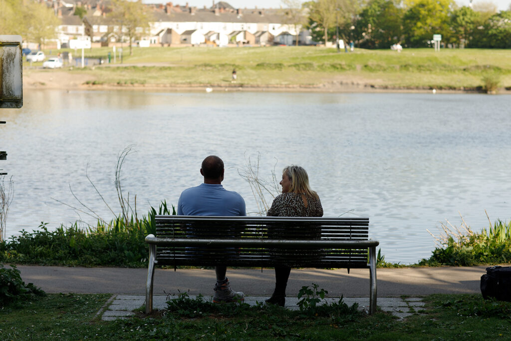 Client with staff member sitting on a bench in Stoke-on-Trent